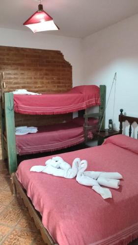 a room with two beds with white towels on them at El Castillito de Juan in Mina Clavero
