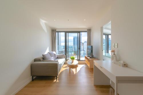 sala de estar con sofá y mesa en Apartment with Brilliant views in Auckland CBD, en Auckland
