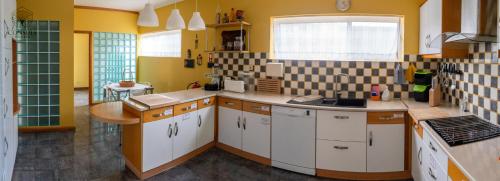 a kitchen with yellow walls and white cabinets at Consuls Residence in Ponta Delgada