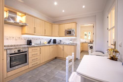 a kitchen with wooden cabinets and a stove top oven at Calahonda Villa La Palma in Mijas