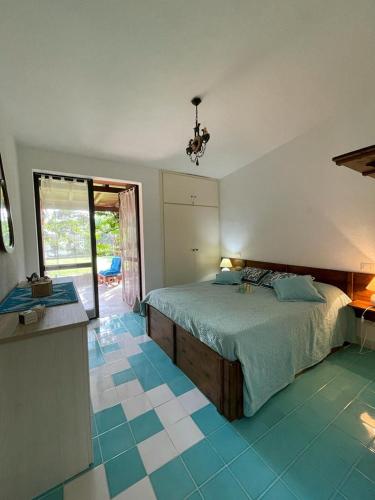 a bedroom with a bed and blue tiled floors at Villa ValePina in Villasimius