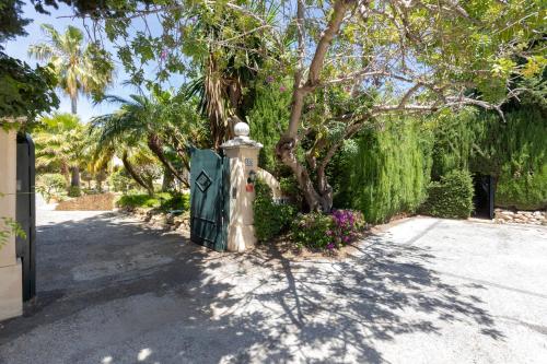 a garden with a fence and a tree and flowers at Calahonda Villa La Palma in Mijas