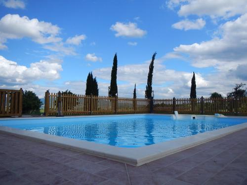 une grande piscine avec une clôture et des arbres dans l'établissement Agriturismo Scaforno Vacanze, à Castelnuovo della Misericordia