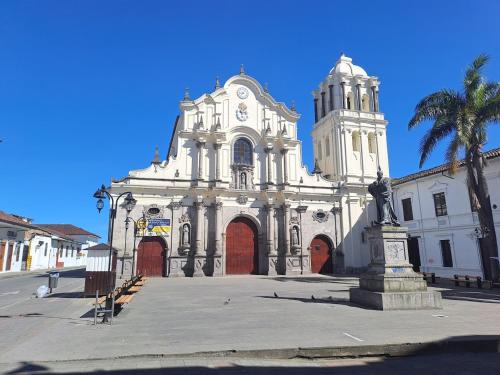 a large white building with a statue in front of it at Hotel La Herreria Colonial in Popayan