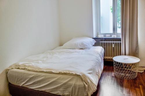 an unmade bed in a small room with a window at Charmante Altbauwohnung in Bonn in Bonn