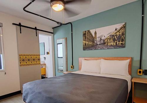 a bedroom with a bed and a painting on the wall at Hotel Escala Colonia Roma in Mexico City