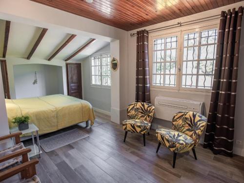 une chambre avec un lit et deux chaises dans l'établissement Pin Parasol, à Roquebrune-sur Argens