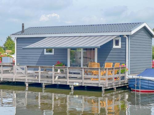 a blue house on a dock on a body of water at Purperreiger 24-32 in Breukelen