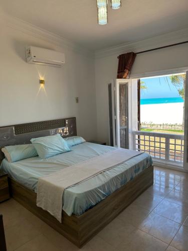 فيلا أول صف على البحر مارينا 5الساحل الشمالي 7 غرف كود 88 في العلمين: غرفة نوم مع سرير مطل على المحيط