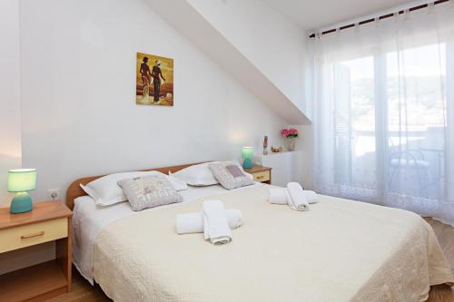 a white bedroom with a bed with towels on it at Apartments by the sea Tisno, Murter - 815 in Tisno