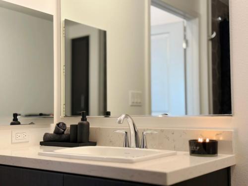 a bathroom with a sink and a large mirror at Cosmopolitan Hollywood Home DTLA view Parking - 10mins to Universal Studios in Los Angeles