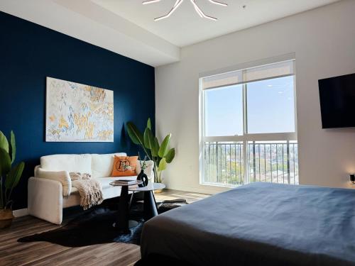 a bedroom with a bed and a couch and a window at Cosmopolitan Hollywood Home DTLA view Parking - 10mins to Universal Studios in Los Angeles