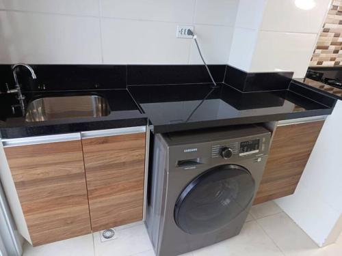 a kitchen with a washing machine and a sink at Apto frente mar maravilhoso centro mongaguá in Mongaguá