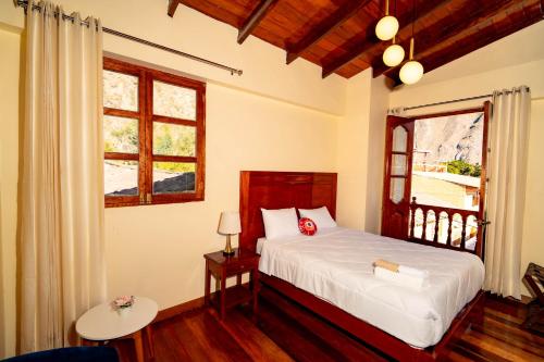 a bedroom with a bed and a window at NUNA SUMAQ Hotel in Ollantaytambo
