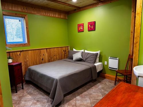 a bedroom with a bed in a green wall at l'appartement in Tadoussac