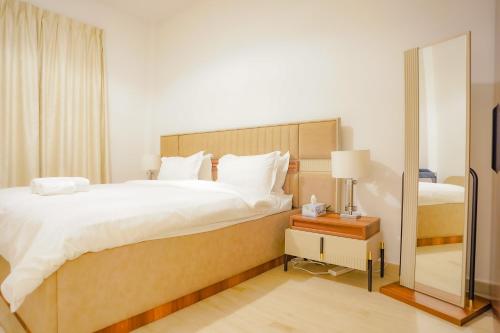 a bedroom with a large bed and a mirror at Spectacular 2BR Apartment Full BurjAlArab View in Dubai