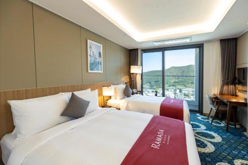 麗水的住宿－Ramada Plaza by Wyndham Dolsan Yeosu，酒店客房设有两张床和窗户。