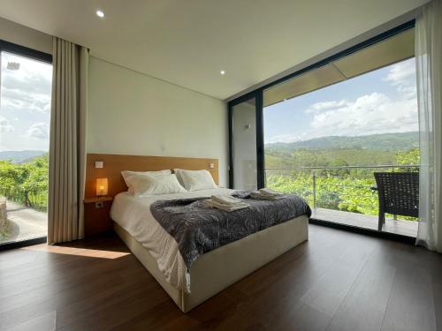 a bedroom with a bed and a large window at Casa da Garrafeira - Quinta da Portela in Terras de Bouro