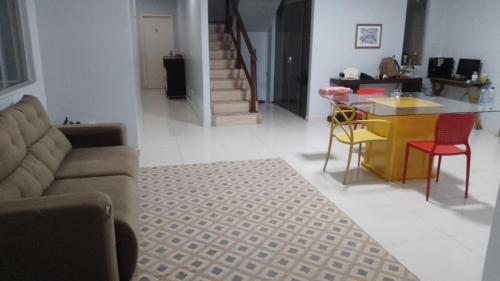a living room with a couch and a table and chairs at Pousada do Bosque-Hostel in Rio Branco
