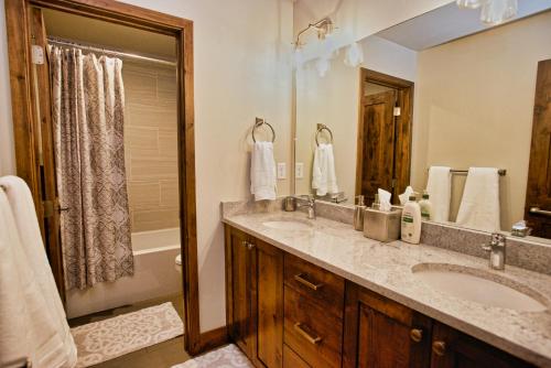 a bathroom with a sink and a large mirror at Silverpine Hideaway by Casago McCall - Donerightmanagement in McCall