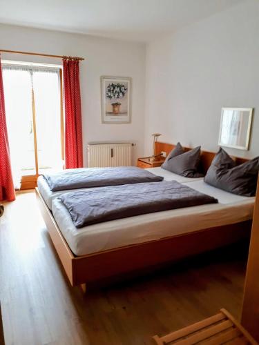 a bedroom with a large bed and a window at Ferienwohnung Hinterstoißer in Berchtesgaden