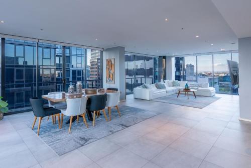 a living room with a table and chairs and a couch at Perfect 4 Bedroom Penthouse close to Casino in Melbourne
