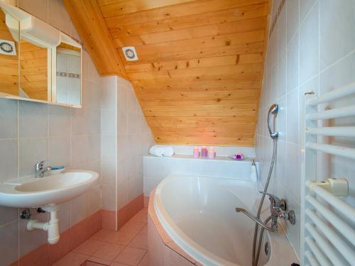 La salle de bains est pourvue d'une baignoire blanche et d'un lavabo. dans l'établissement Hotel Bella, à Prague