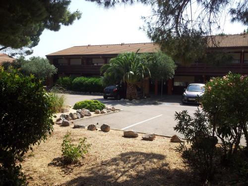 a parking lot with rocks in front of a building at Campanile Perpignan Sud in Perpignan