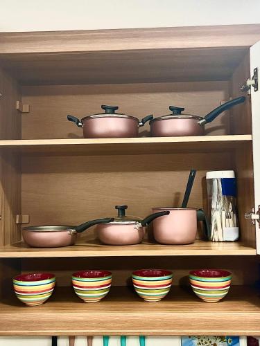 a shelf full of pots and pans in a kitchen at Life Flats Temporada com Bela vista à 50m da Praia in Recife