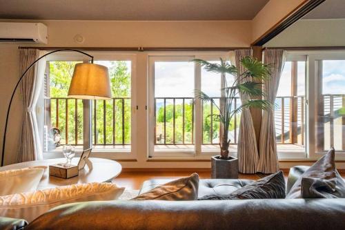 a living room with a couch and a large window at Private Lodging HAN in Lake Toya
