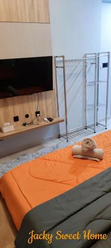 a bedroom with a bed with an orange blanket at Jacky Sweet Home - Entire Condo in Buli Sim Sim