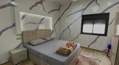a bedroom with a tree mural on the wall at شقق العيون in Laayoune