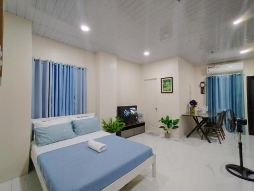 a bedroom with a blue bed and a desk at Quirino hub (404) in Davao City