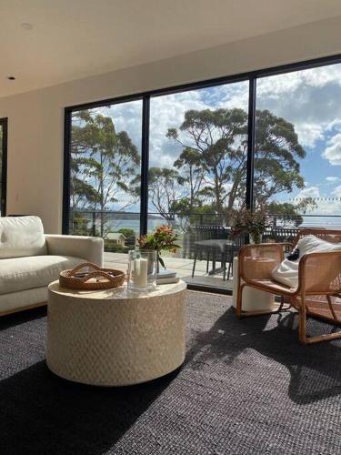 a living room with a couch and a table at White Beach Retreat - Luxurious Water Views in White Beach