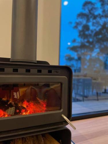 a toaster oven with a fire inside of it at White Beach Retreat - Luxurious Water Views in White Beach