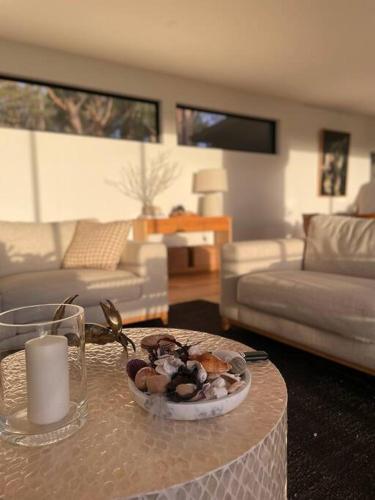 a living room with a table with a bowl of food at White Beach Retreat - Luxurious Water Views in White Beach