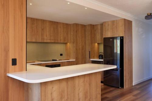 Beachside Palm Beach Luxury - 2 Bedroom Apartment في غولد كوست: مطبخ مع كونتر ابيض وثلاجة سوداء