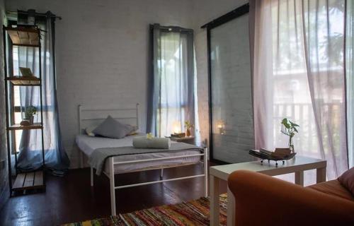 a bedroom with a bed in a room with windows at Langkawi Rouhi Retreats by uBook in Kuah