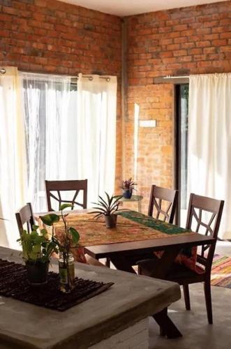 a dining room with a table and chairs and windows at Langkawi Rouhi Retreats by uBook in Kuah