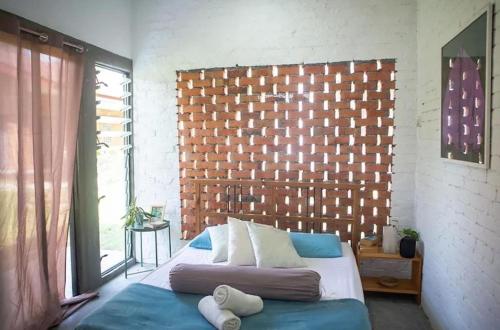a bedroom with a bed and a brick wall at Langkawi Rouhi Retreats by uBook in Kuah
