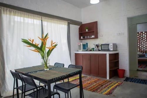 a room with a table and chairs and a kitchen at Langkawi Rouhi Retreats by uBook in Kuah