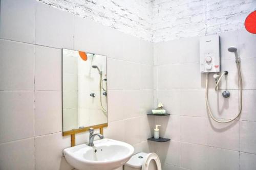 a white bathroom with a sink and a shower at Langkawi Rouhi Retreats by uBook in Kuah