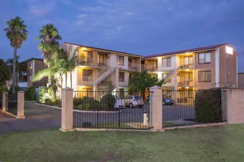 a large apartment building with a fence in front of it at Apartment 22 Burswood in Perth