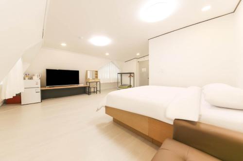 a bedroom with a large bed and a flat screen tv at Seorak HOT Spring Mammoth Resotel in Sokcho