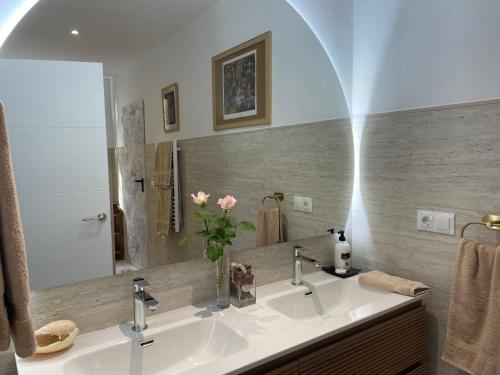 a bathroom with a sink and a vase of flowers at Finca vista de la roca in Estepona