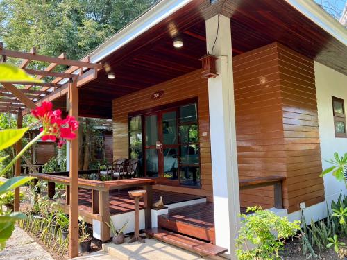 a small house with a deck with a table at Maikaew Damnoen Resort in Damnoen Saduak