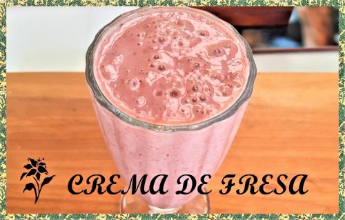 a pink drink in a glass sitting on a table at Eco-HOTEL HOGAR EN LA MONTAÑA HOME SWEET HOME in La Vega