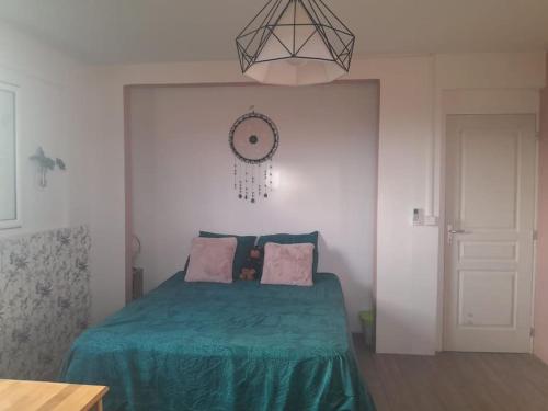 a bedroom with a bed with a green blanket at Location villa ventilée T3 DUCOS in Ducos