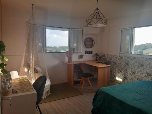a bedroom with a bed and a desk and a deskablish at Location villa ventilée T3 DUCOS in Ducos