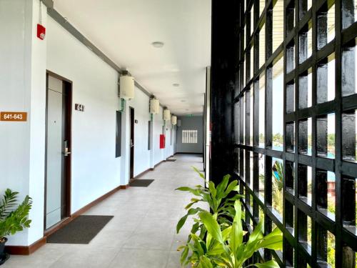 an empty corridor of an office building with plants at Maikaew Damnoen Resort in Damnoen Saduak